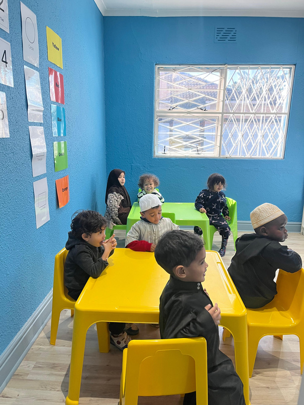 Young children seated at tables during a Madrassa An-Nur wal-Huda class run by DailyDawahs in Cape Town